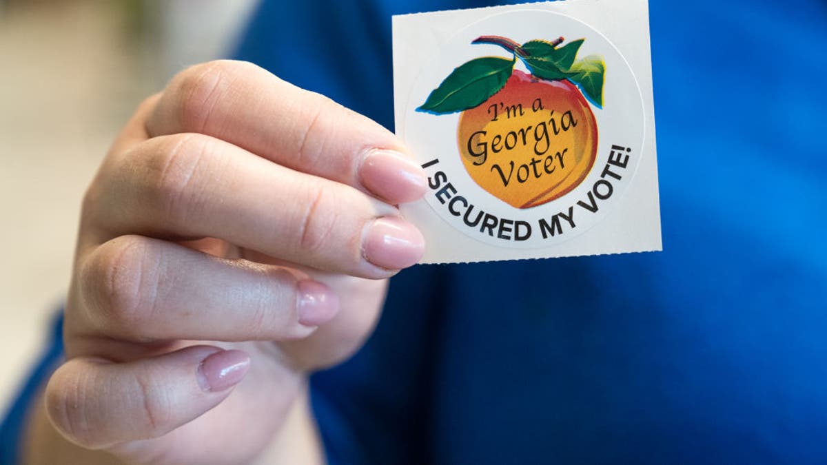 hand holding Georgia voted sticker