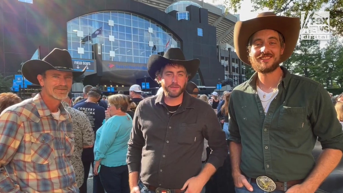 Three concert attendees from Greensboro wearing cowboy hats