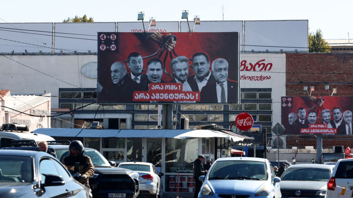 Campaign billboards of the ruling Georgian Dream Party depicting opposition parties' leaders and activists and reading in Georgian "No to war, No to Agents" sit in Tbilisi on Oct. 22, 2024, ahead of Oct. 26 parliamentary elections.