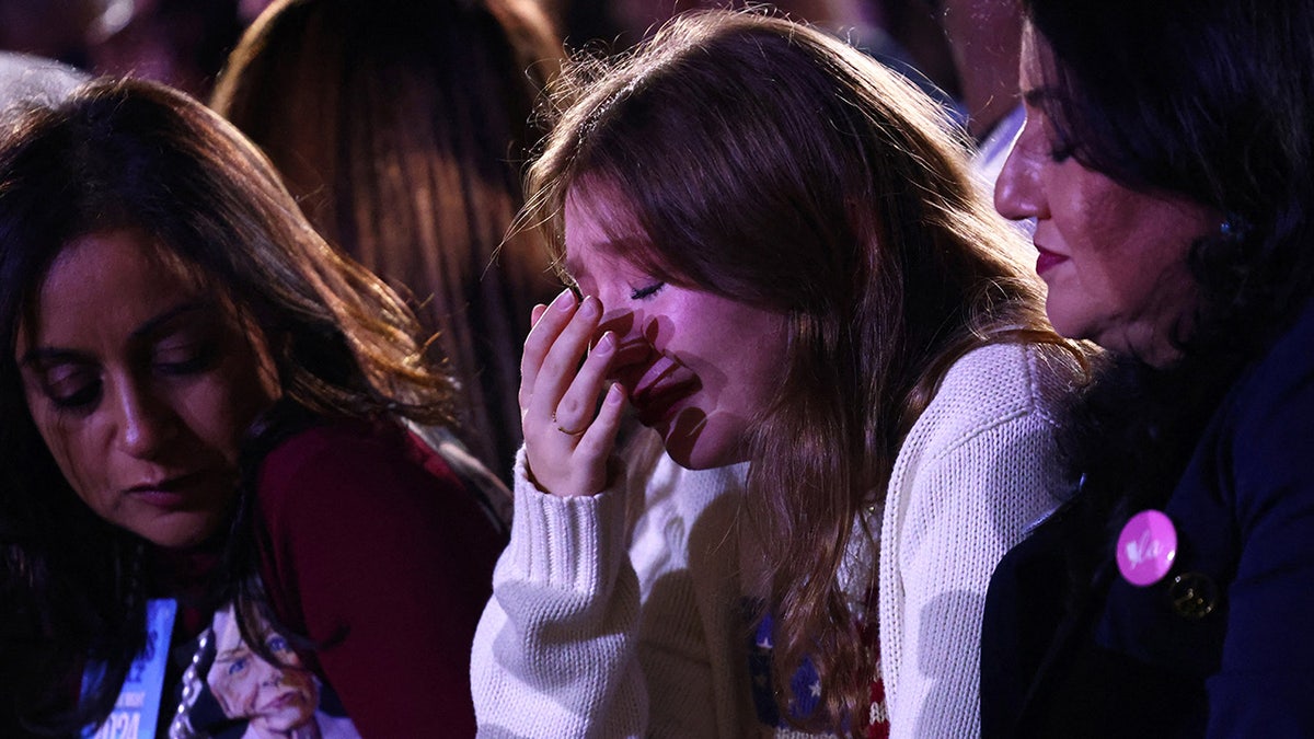 crying Harris supporter with other Harris supporters