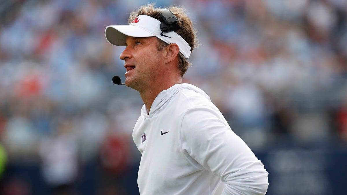 Lane Kiffin looks on