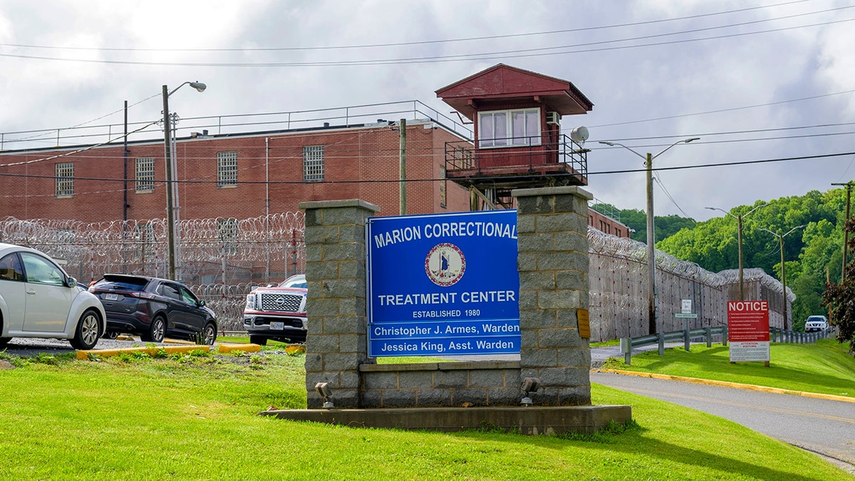 prison building in background, sign foreground