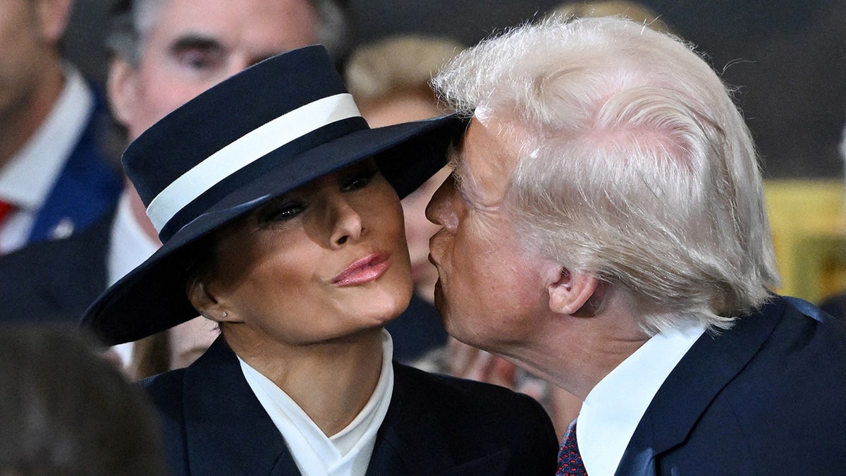 US President-elect Donald Trump kisses Melania Trump as he arrives for the inauguration ceremony