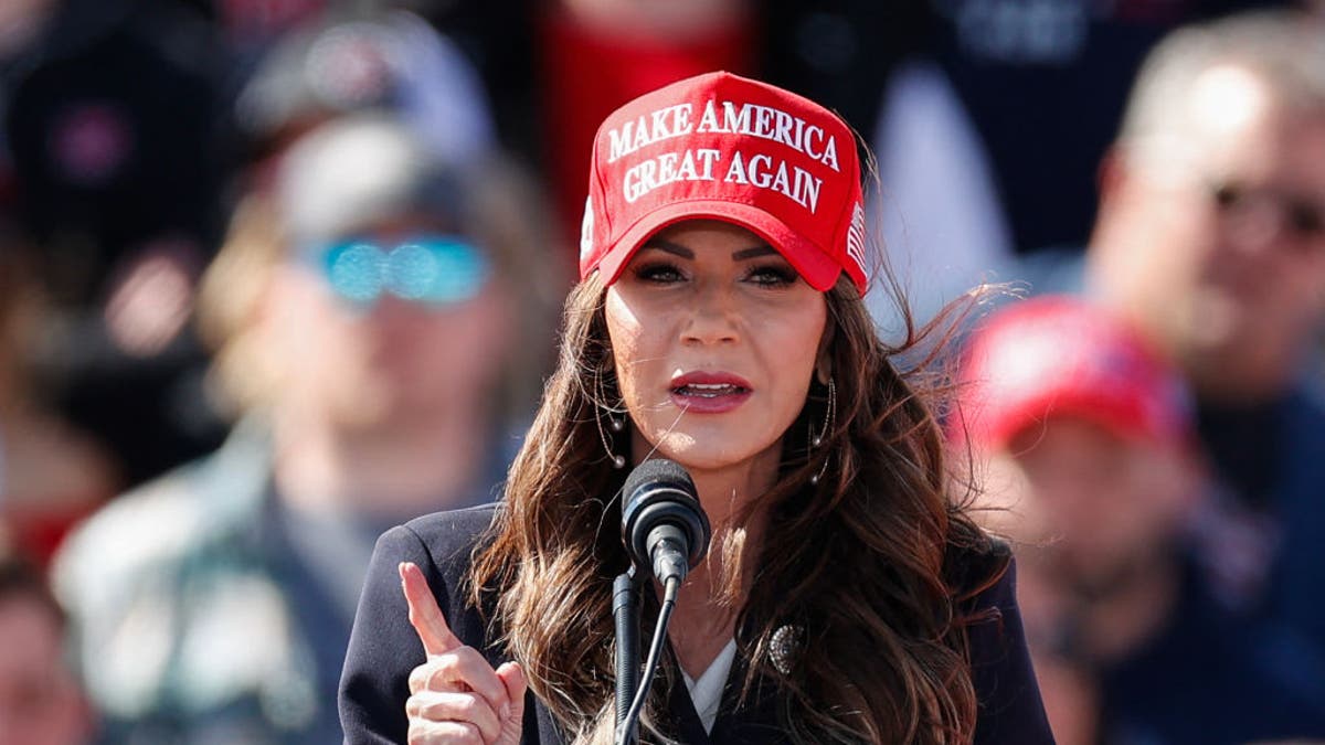 Noem in red MAGA hat closeup shop speaking at rally