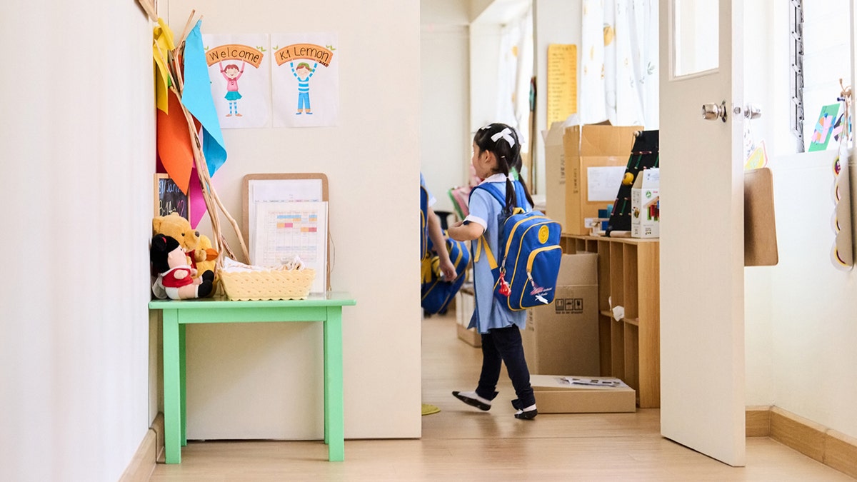 Student with schoolbag entering the classroom