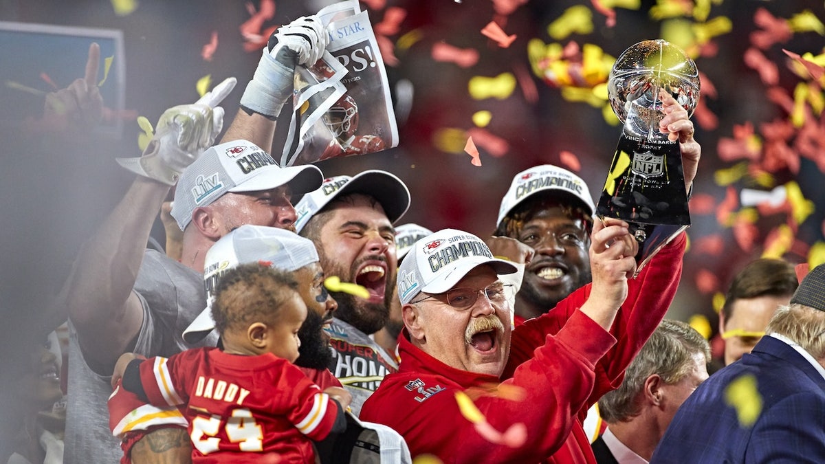 Kansas City Chiefs coach Andy Reid victorious, holding up the Vince Lombardi trophy after winning Super Bowl LIV against the San Francisco 49ers at Hard Rock Stadium.