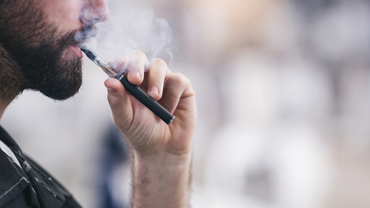 man smoking a vape