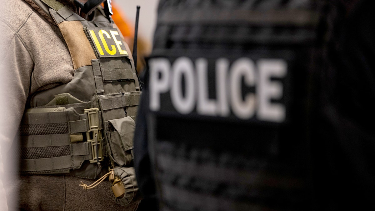 Man with vest that says "ICE." Nearby, the word "POLICE" can be seen.