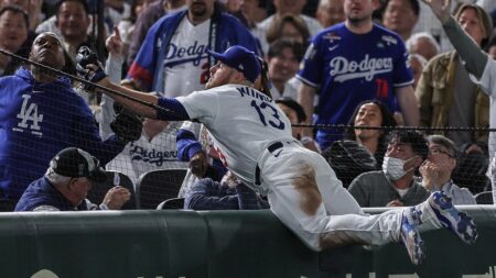 Dodgers’ Max Muncy looks stunned as ex-NFL quarterback Rodney Peete snags foul ball from the stands