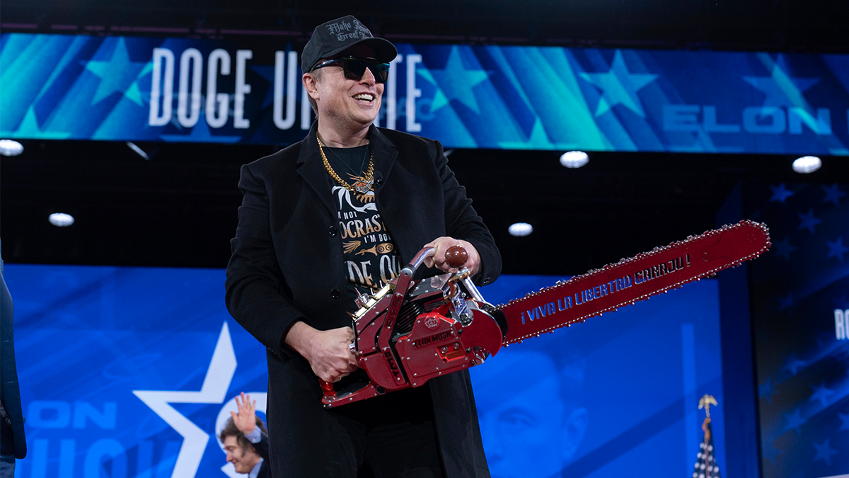 Elon Musk, who steers President Donald Trump's Department of Government Efficiency (DOGE), which is cutting government fraud and slashing the federal workforce, wields a chainsaw during an appearance at CPAC, on Feb. 20, 2025 in National Harbor, Maryland