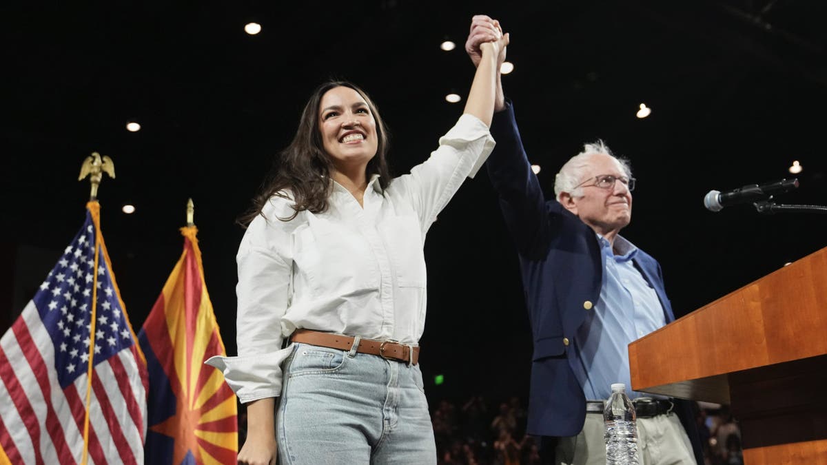 AOC holds hands with Sen. Bernie Sanders