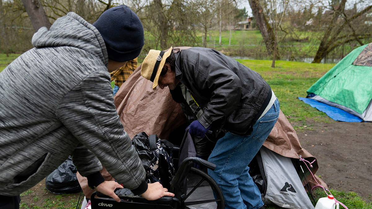 A volunteer holds on to a wheelchair