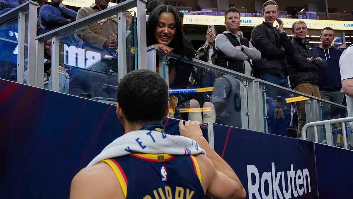 Steph Curry talks to his wide Ayesha Curry