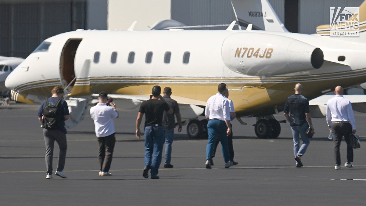 The Tate brothers walk on the tarmac at the airport in Miami after they speak to Fox News Digital