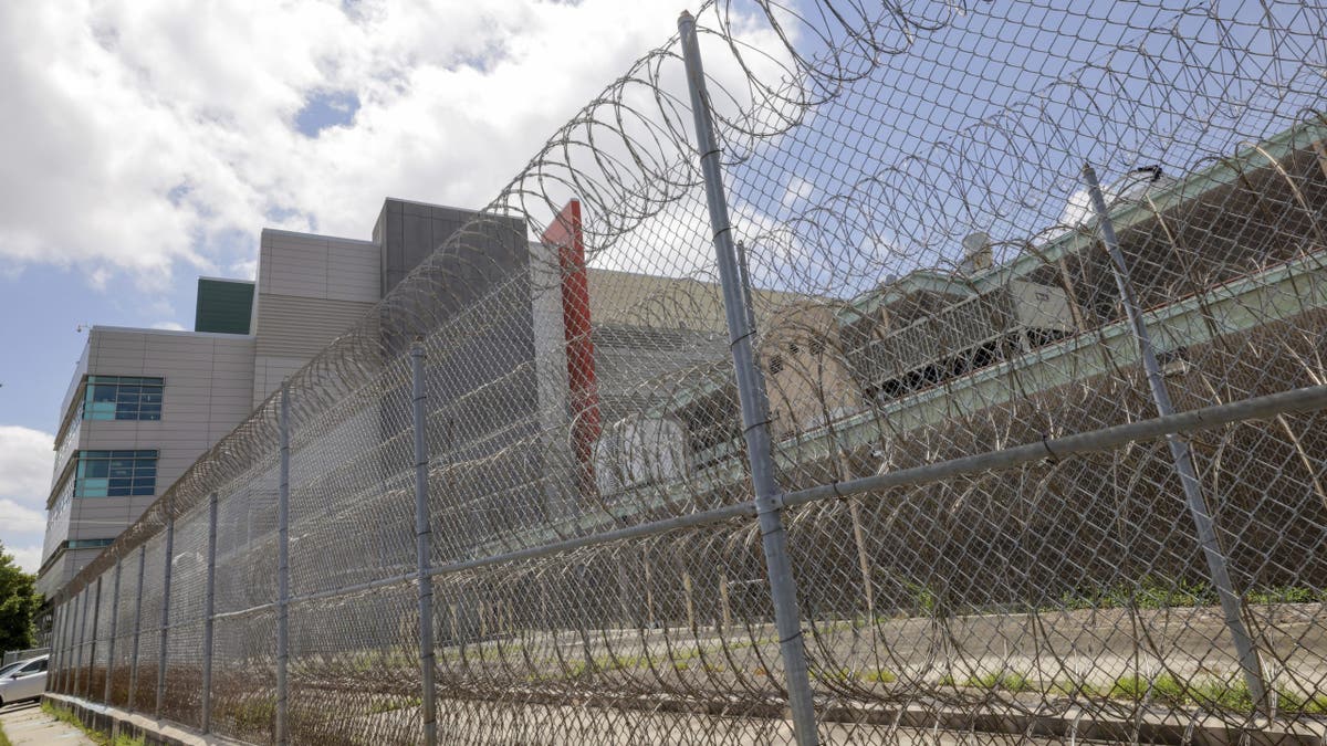Outside of the Orleans Parish jail, barbed wire fence and recreation yard.