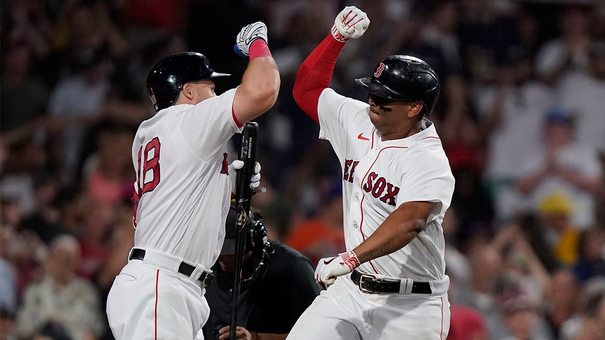 Rafael Devers celebrates with Adam Duvall