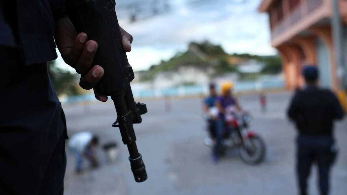 TEGUCIGALPA, HONDURAS - JULY 20: Police patrol the streets of a gang ridden neighborhood on July 20, 2012 in Tegucigalpa, Honduras. Honduras now has the highest per capita murder rate in the world and its capital city, Tegucigalpa, is plagued by violence, poverty, homelessness and sexual assaults. With an estimated 80% of the cocaine entering the United States now being trans-shipped through Honduras, the violence on the streets is a spillover from the ramped rise in narco-trafficking. (Photo by Spencer Platt/Getty Images)