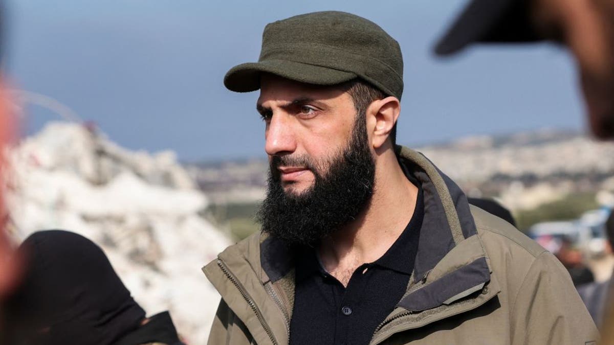 Hayat Tahrir al-Sham, then jihadist group's chief Abu Mohamed al-Jolani, checks the damage following an earthquake in the village of Besnaya in Syria's rebel-held northwestern Idlib province at the border with Turkey, on February 7, 2023. Since becoming the country's leader, Jolani is now known as Ahmad al-Sharaa.