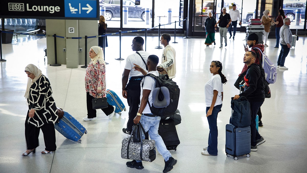 Passengers walk through Newark Airport
