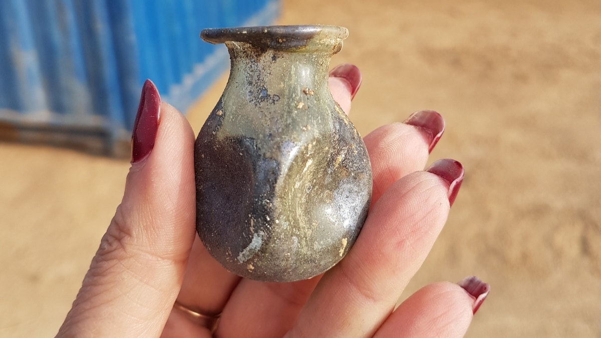 Hand holding ancient jar