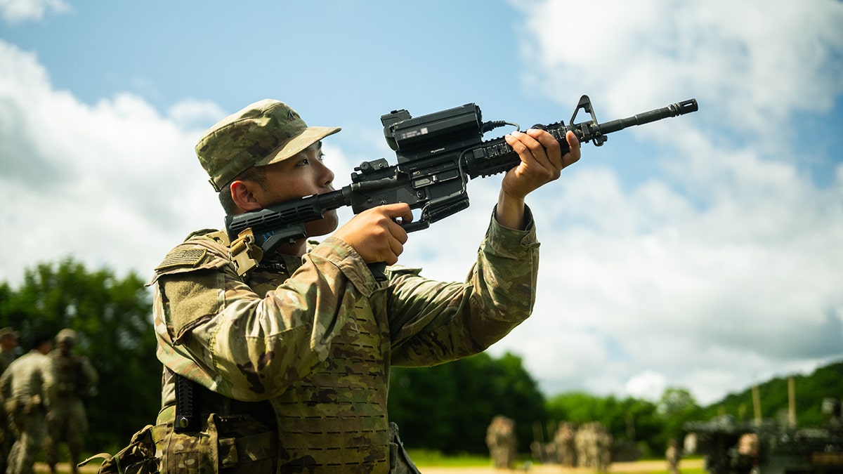 A U.S. Soldier peers through a Smartshooter SMASH 2000L attached to a M4A1 rifle