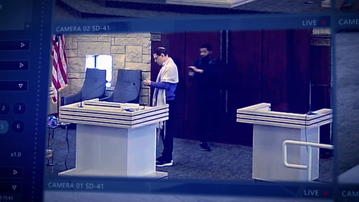 Security footage shows Rabbi Cytron-Walker with Malik Faisal Akram holding his gun.