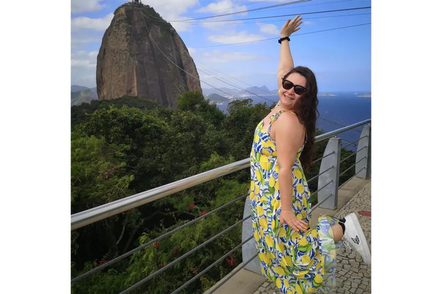 A woman in a yellow dress overlooking a mountain