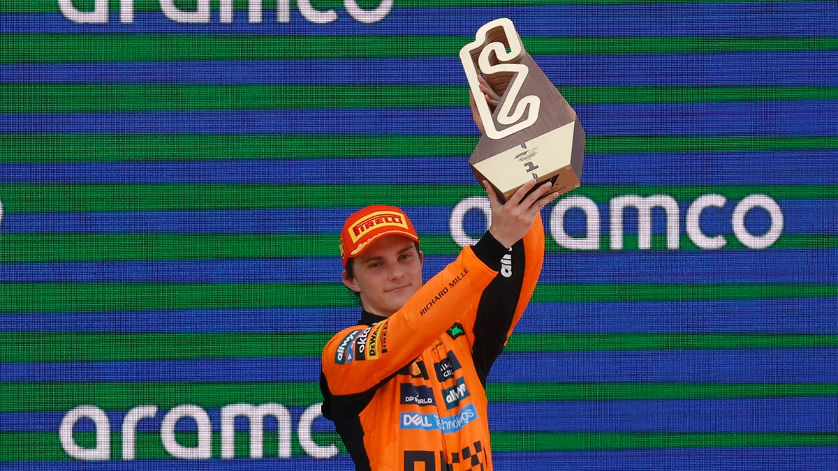 Oscar Piastri raises the trophy