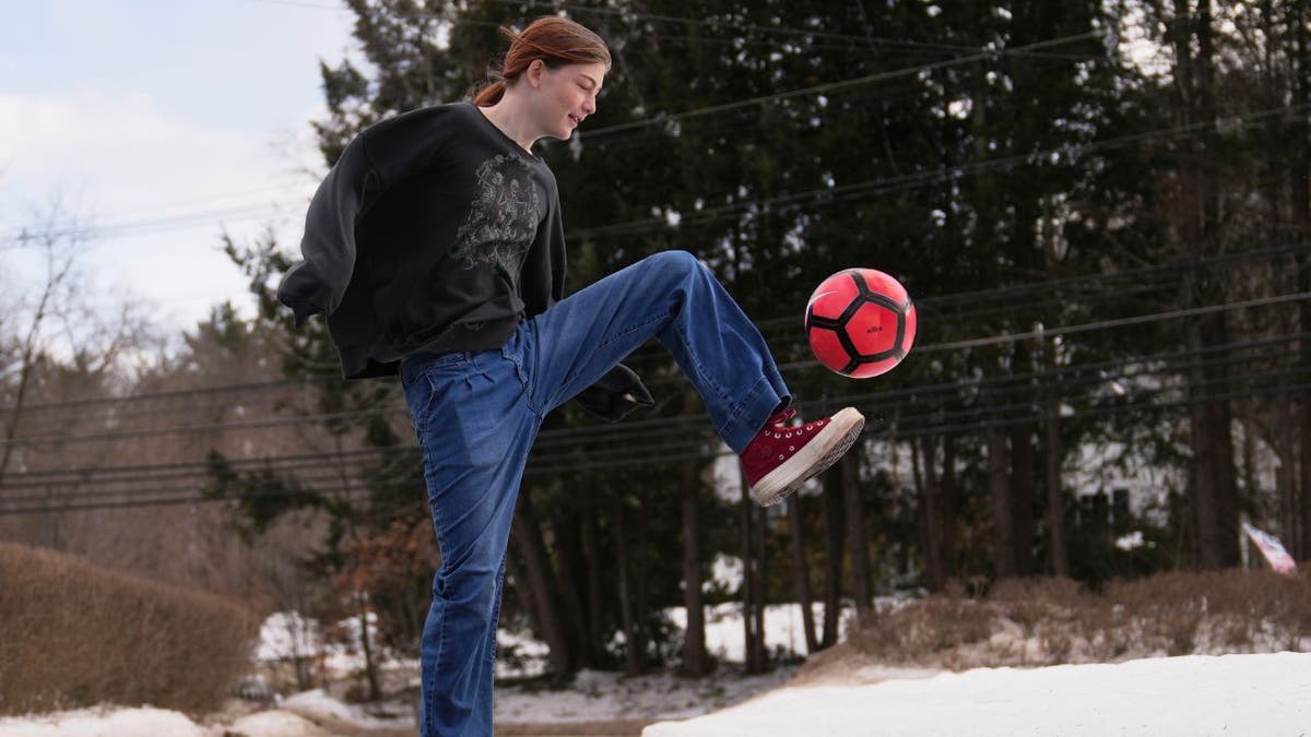 Transgender athlete Parker Tirrell kicking a soccer ball