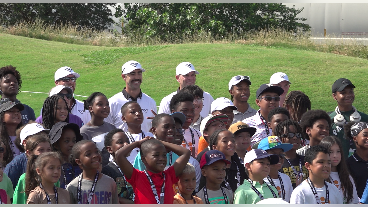 Kids from the greater DFW area pose for a picture with players from LIV Golf's HyFlyers GC. 