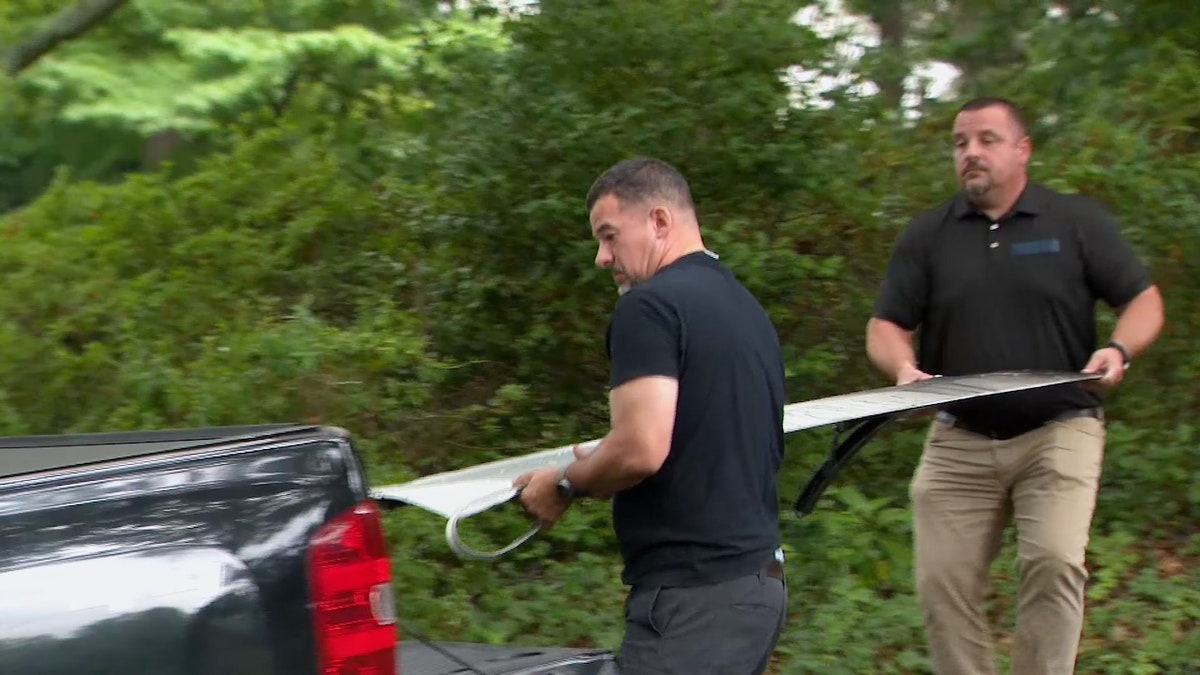 Workers remove the wing flap that fell off of a Boeing 737-900 from a driveway in North Carolina.