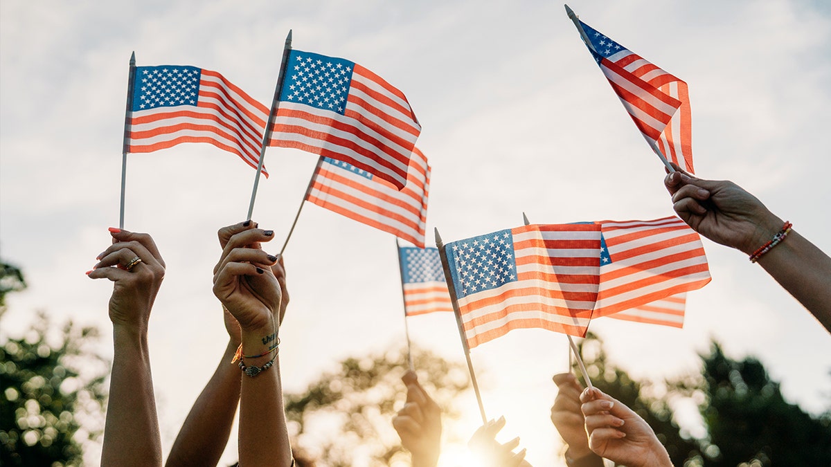 People hold American flags on July Fourth