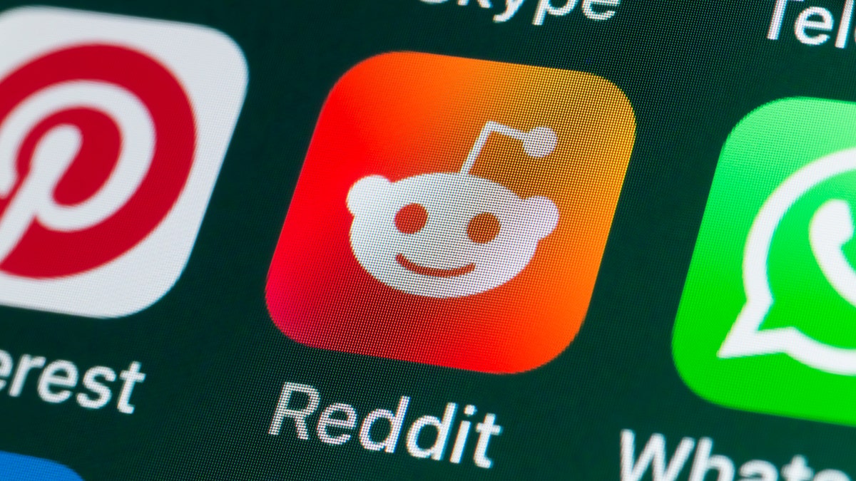 Reddit app logo seen on Iphone next to pinterest and whatsapp logos