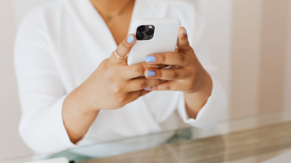 Female Apple iPhone user types on screen