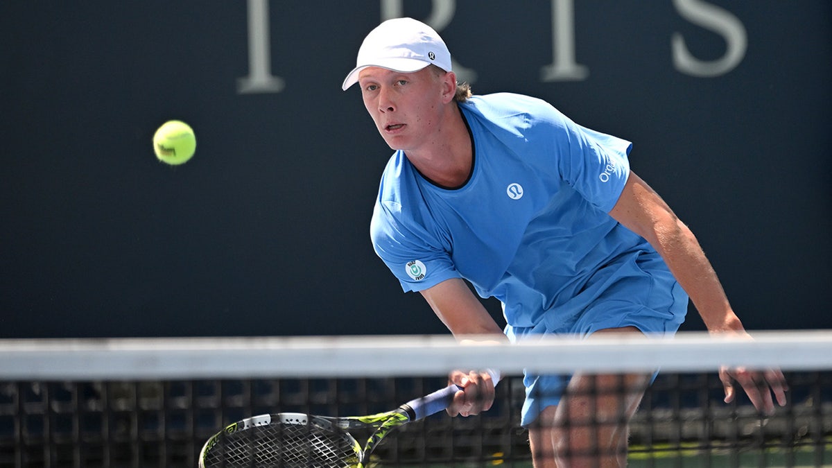 Ethan Quinn hits tennis ball