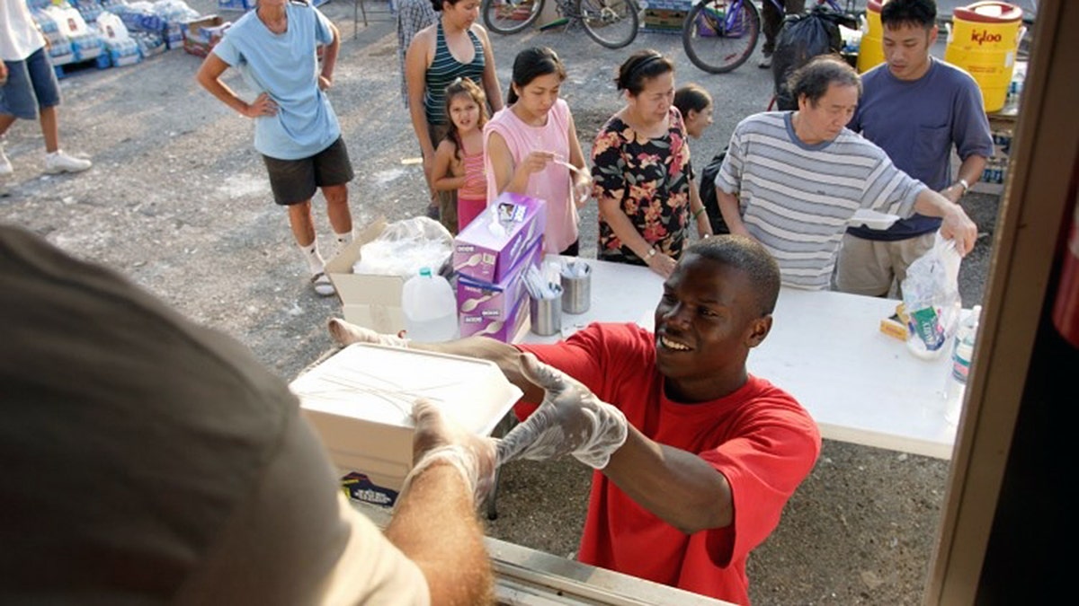A man receiving a box from a volunteer