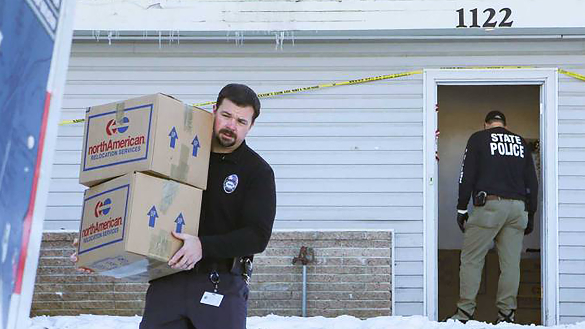 Anthony Dahlinger carrying boxes through the snow outside 1122 King Road