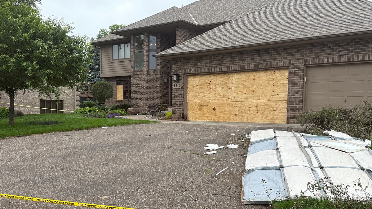 large beign house with garage door replaced with wooden slab