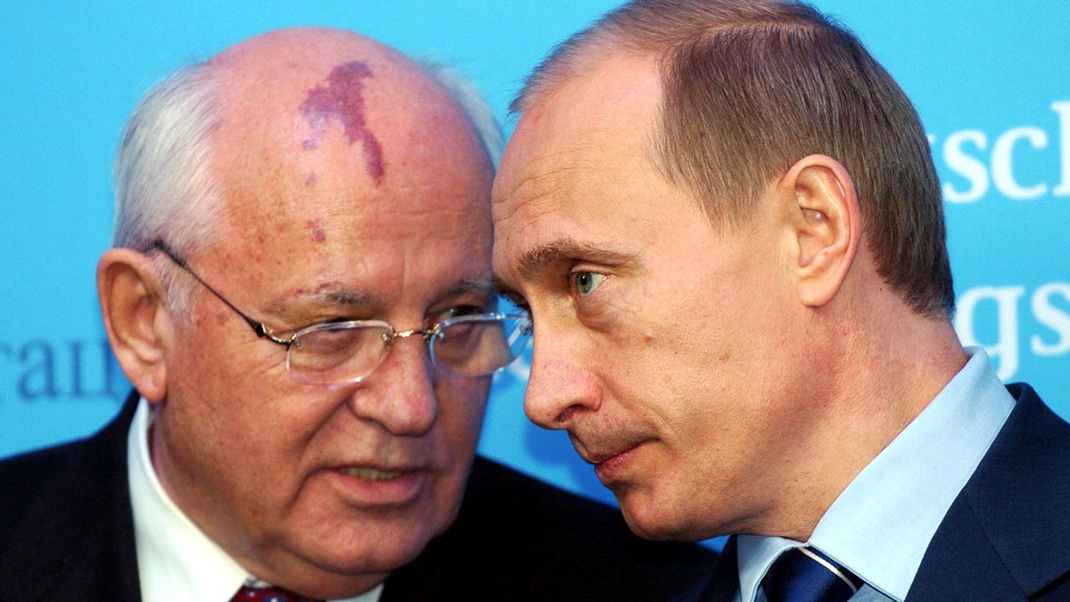 Putin listens to former Soviet leader Gorbachev