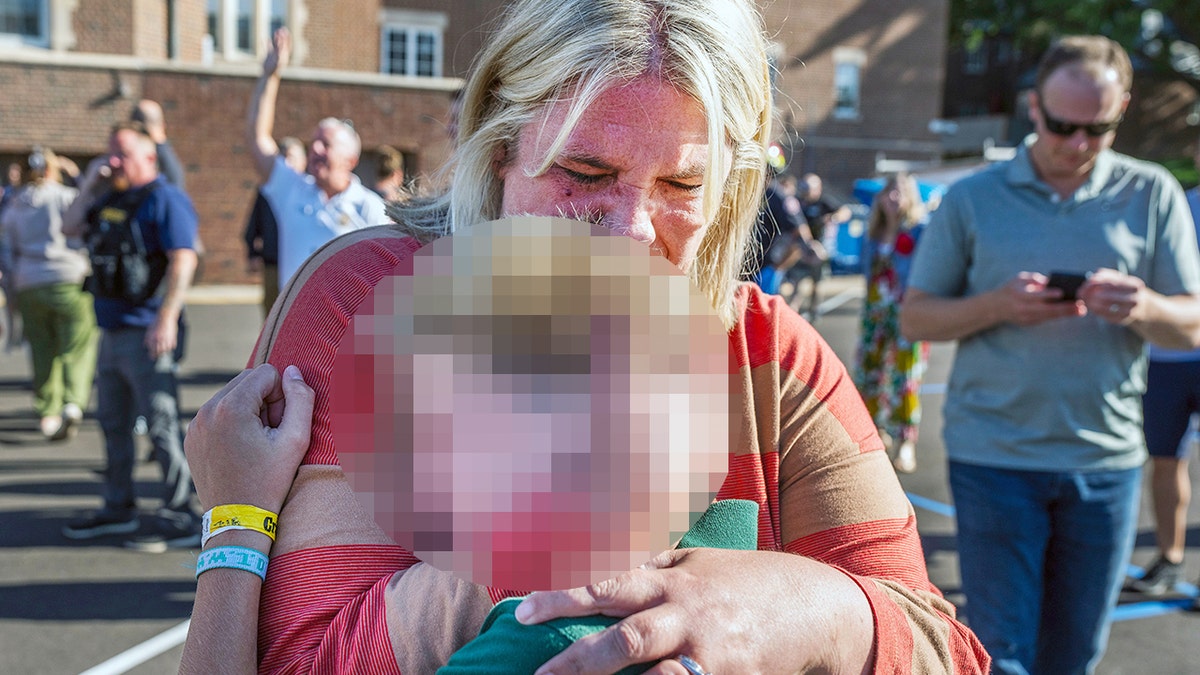 Guardian with student after a mass shooting at a catholic school