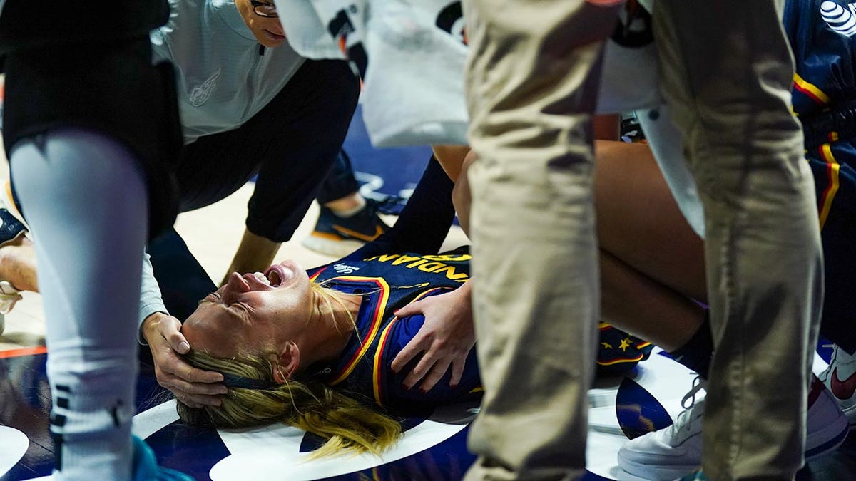 Sophie Cunningham in pain with trainers looking on
