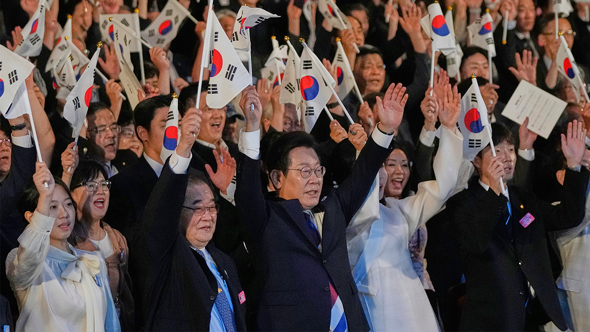 South Korean President Lee Jae Myung waves the national flag and cheers