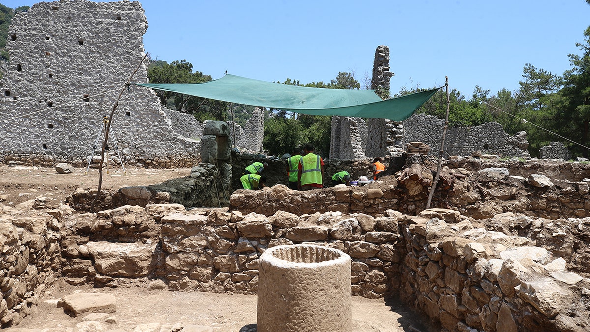 Archaeologists working at tent at site