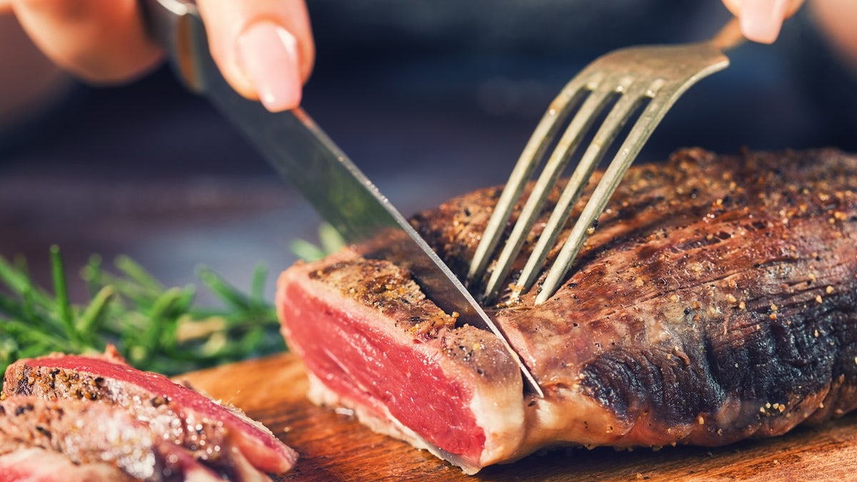 Woman cutting steak
