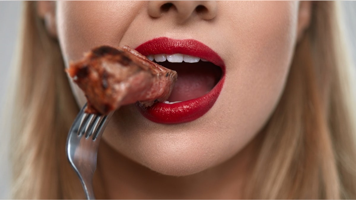 Woman eating steak