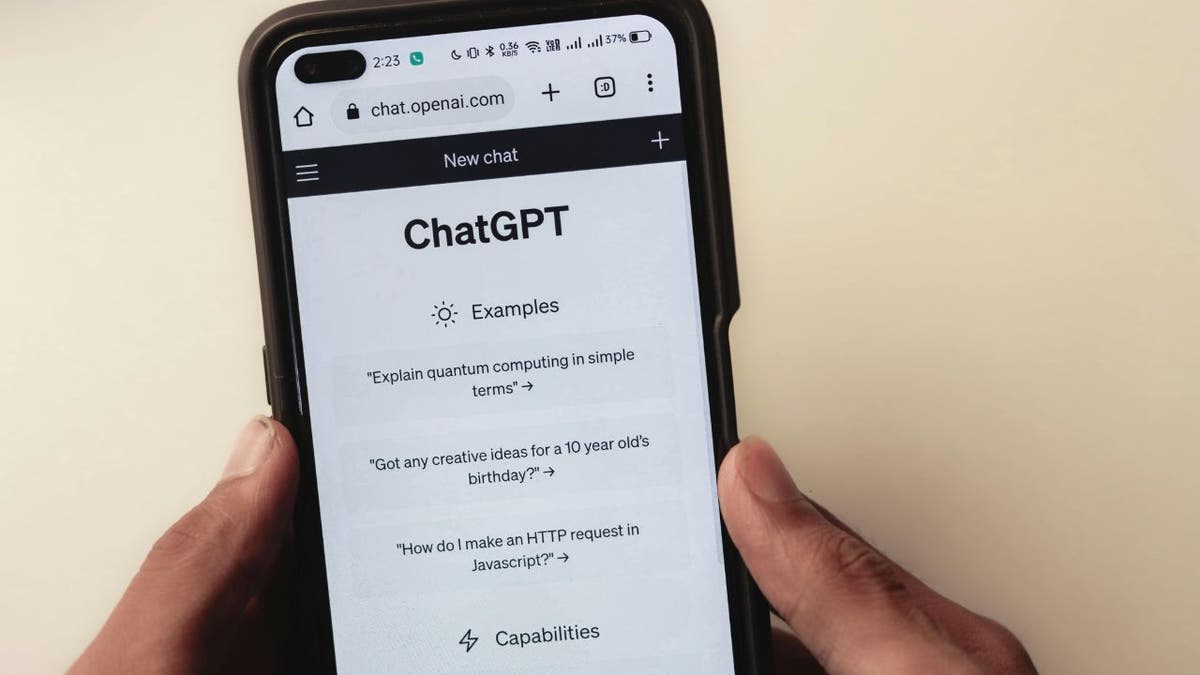 Person holding phone with ChatGPT page open on it, representing story about scammers who can exploit data from just one ChatGPT search