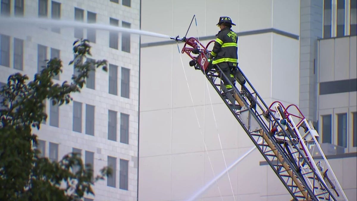 A firefighter sprays water at a building in downtown Baltimore.