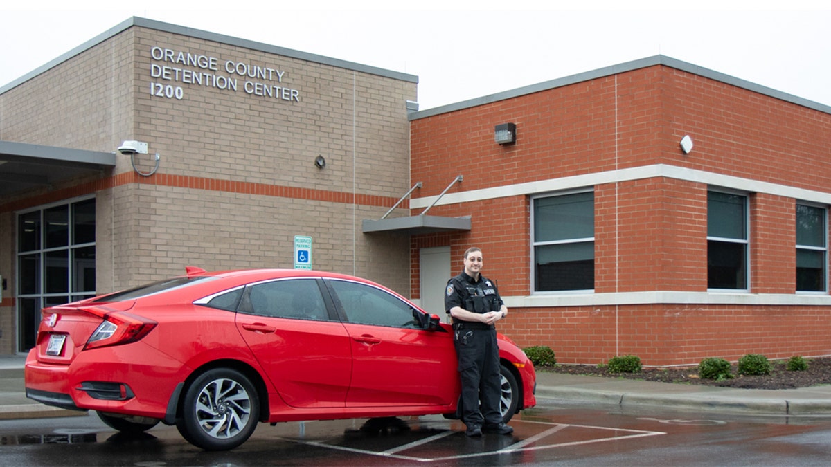 Brian Edwards poses for a picture in front of a car