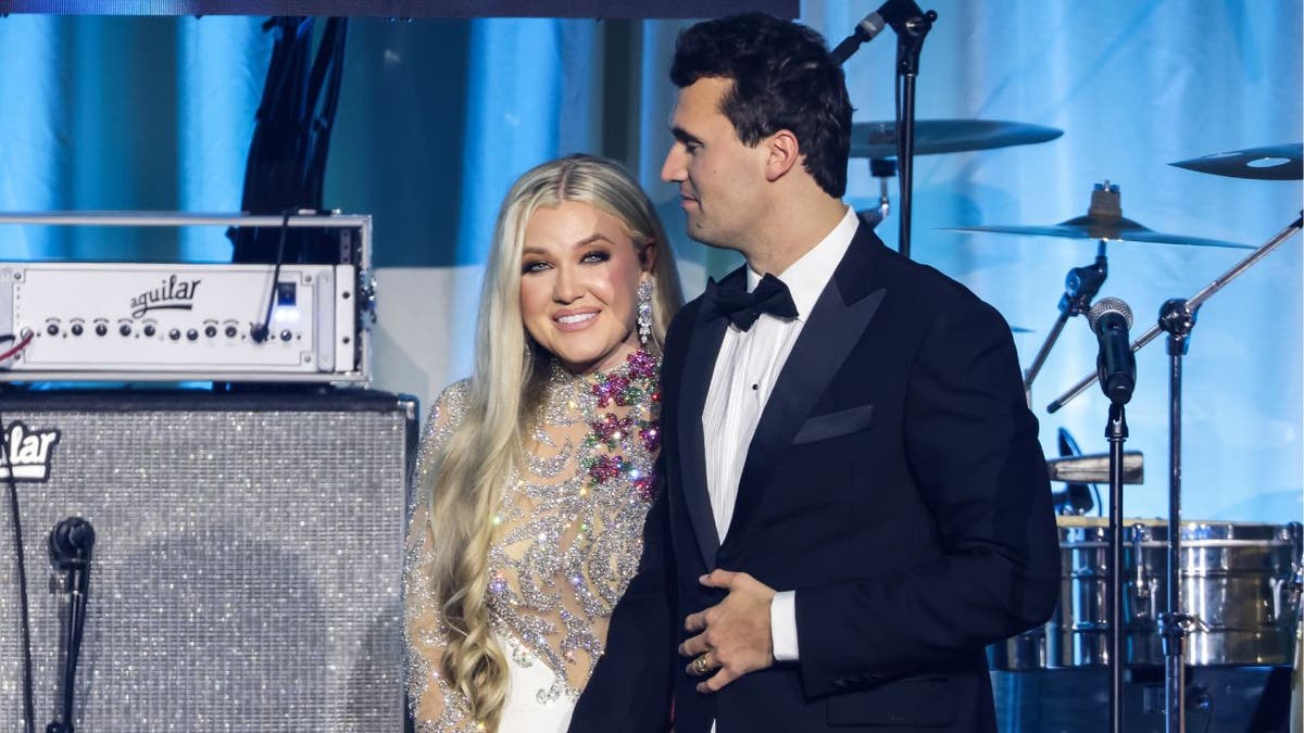 Charlie and Erika Kirk stand together on stage at event