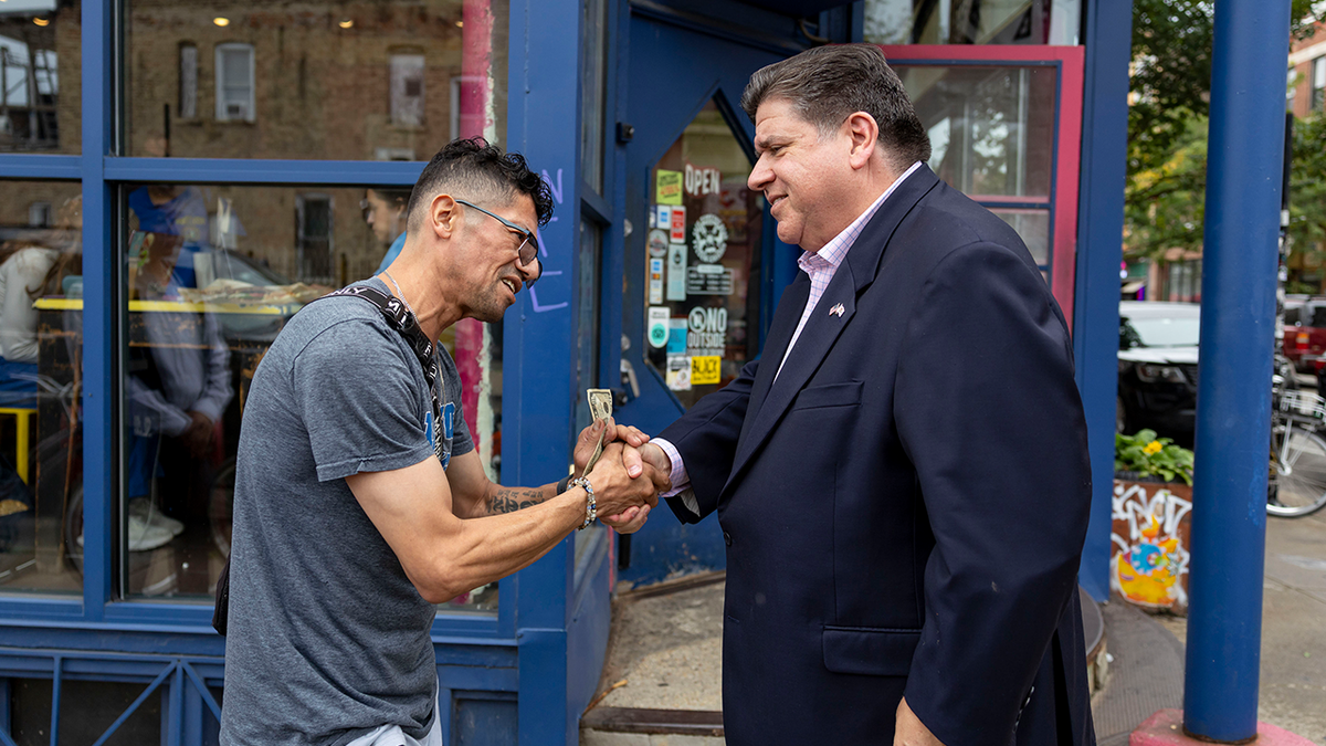 Antonio Cacho, who is originally from Mexico, thanks Gov. JB Pritzker for his work on Sept. 3, 2025, outside Jumping Bean Cafe in the Pilsen neighborhood of Chicago.